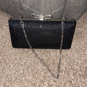 Small black and silver wristlet. Sequenced now clip on top.